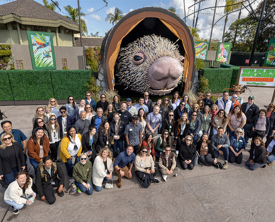 employees posing in front of animatronic